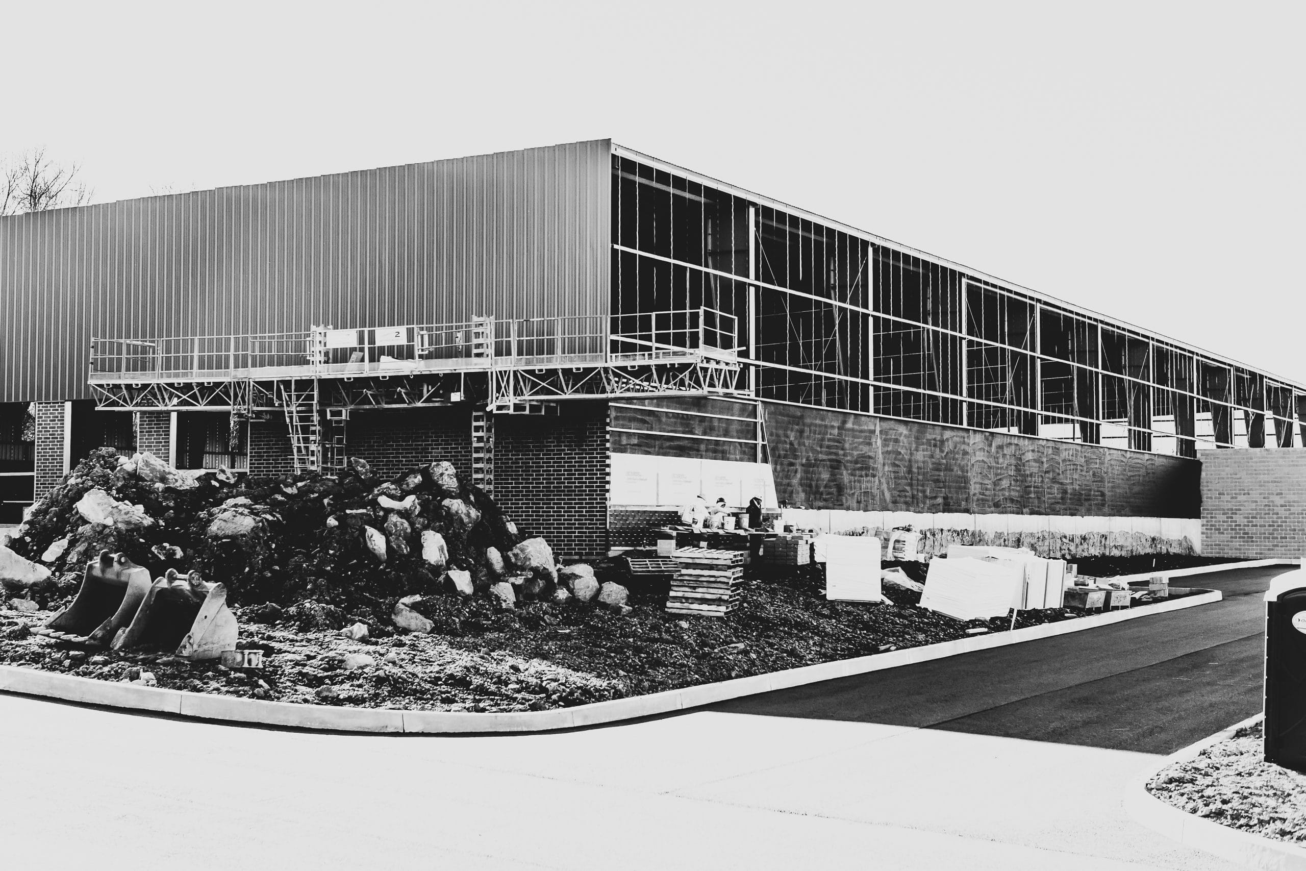 Black and white wide-shot of new glass facility mid-construction.
