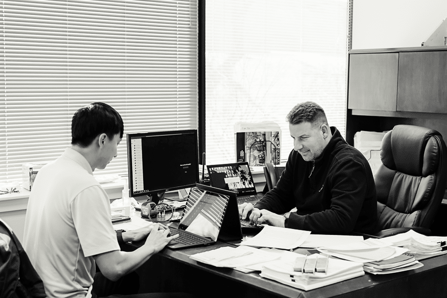 Black and white portrait of Viwinco team members working at desk.