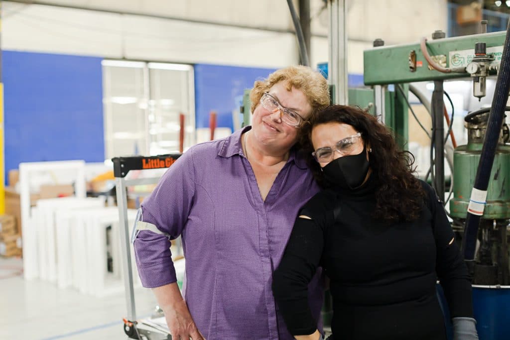 Two team members posing together in Viwinco glass facility.