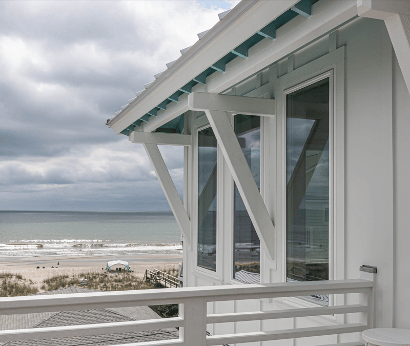 Viiwnco Impact windows in foreground, cloudy beach scene in background.